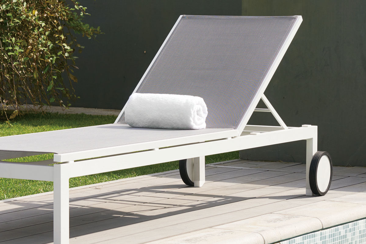 Bain de soleil en aluminium haut de gamme blanc avec textilène gris clair, structure élégante à peinture époxy, roulettes.