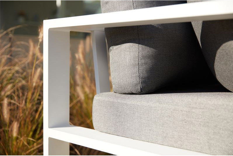 Salon de jardin d'angle modulable en aluminium blanc, coussins gris haut de gamme au design épuré, élégance méditerranéenne.