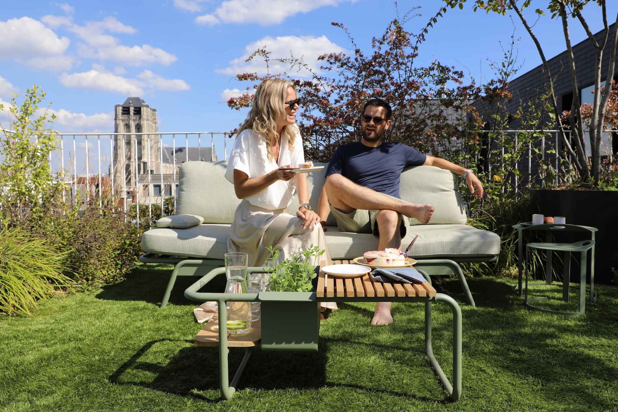 Salon de jardin modulable Sunny en aluminium vert mat avec coussins gris clairs, design belge, élégance méditerranéenne.
