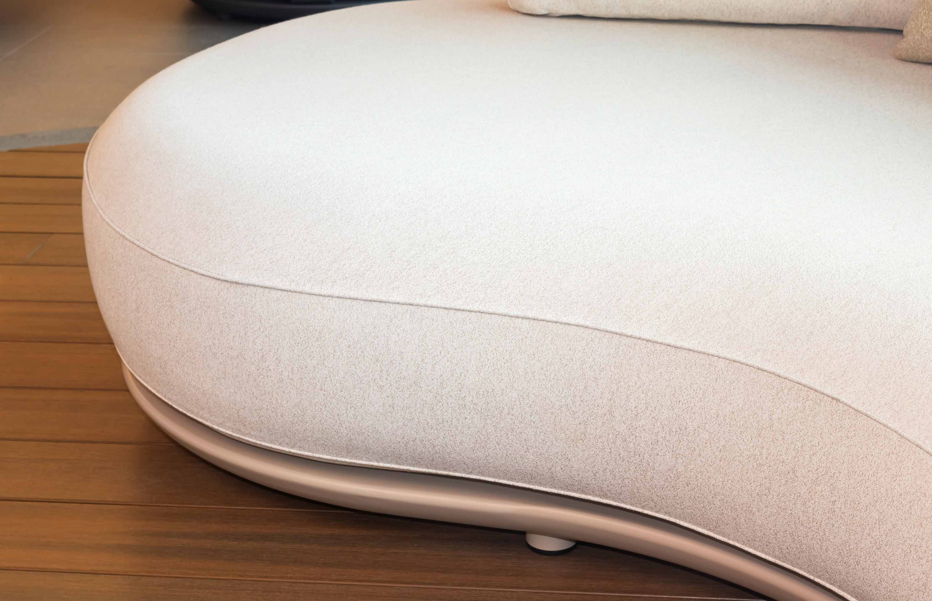 Assise incurvée en tissu en fibre acrylique beige clair, design italien élégant et luxe.