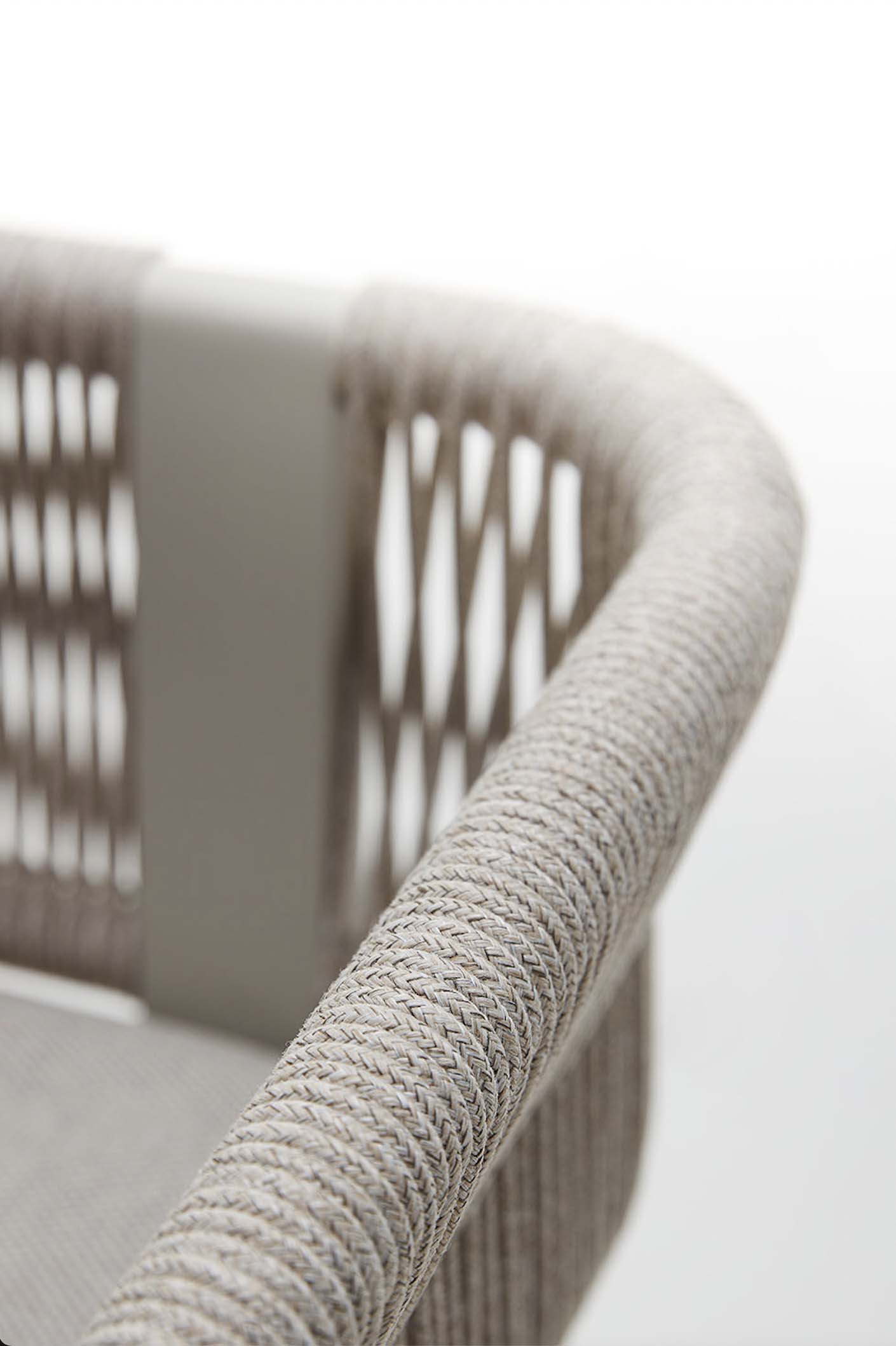 Détail d'un fauteuil d'extérieur moderne en aluminium avec accoudoir en corde tressée beige et coussin déhoussable déperlant.