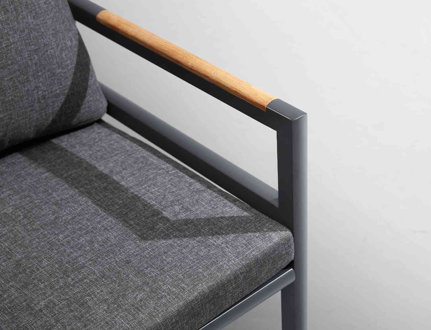 Détail d’un accoudoir en aluminium inoxydable mat avec insert en Teck FSC, coussin gris foncé déperlant et déhoussable,.