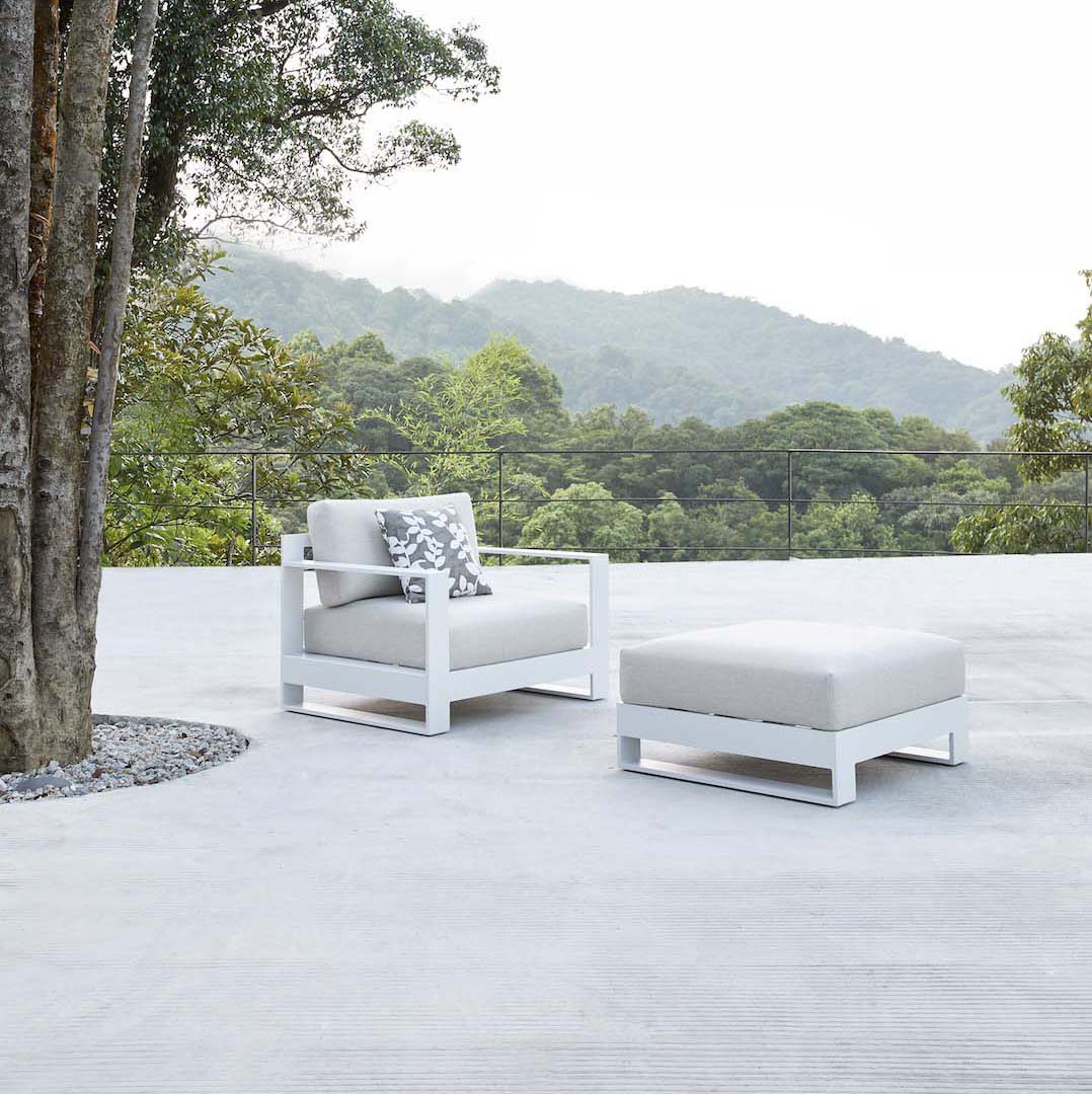 Fauteuil de jardin blanc en aluminium haut de gamme avec coussin en tissu oléfine Sunproof, repose-pied assorti, design luxe.