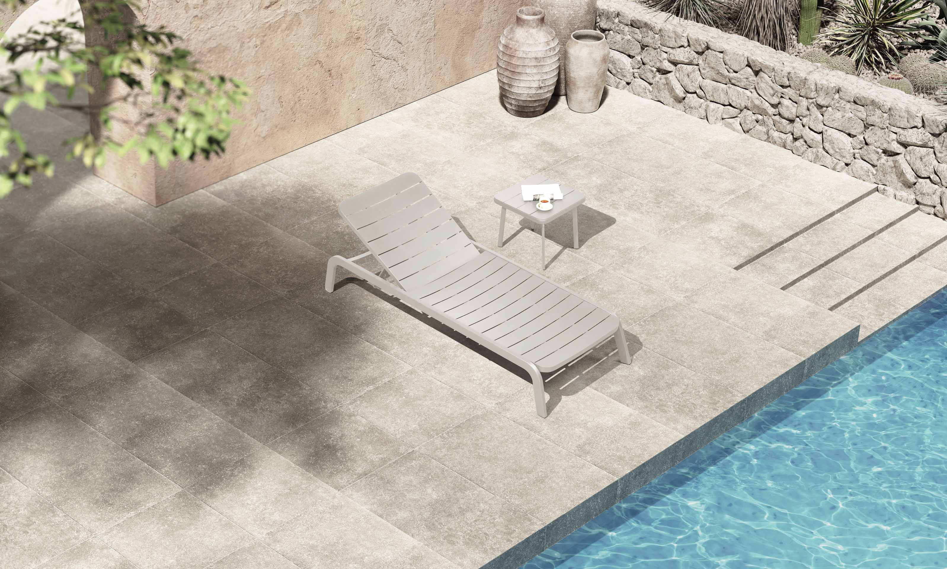 Bain de soleil extérieur bleu en aluminium haut de gamme avec peinture epoxy, design innovant, empilable, posé au bord d’une pisicne.