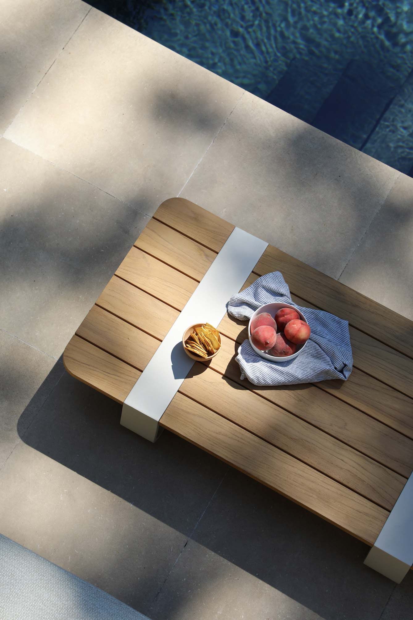 Table basse compacte en Teck FSC naturel avec structure en aluminium design blanc, style luxe méditerranéen, tissu 100%.