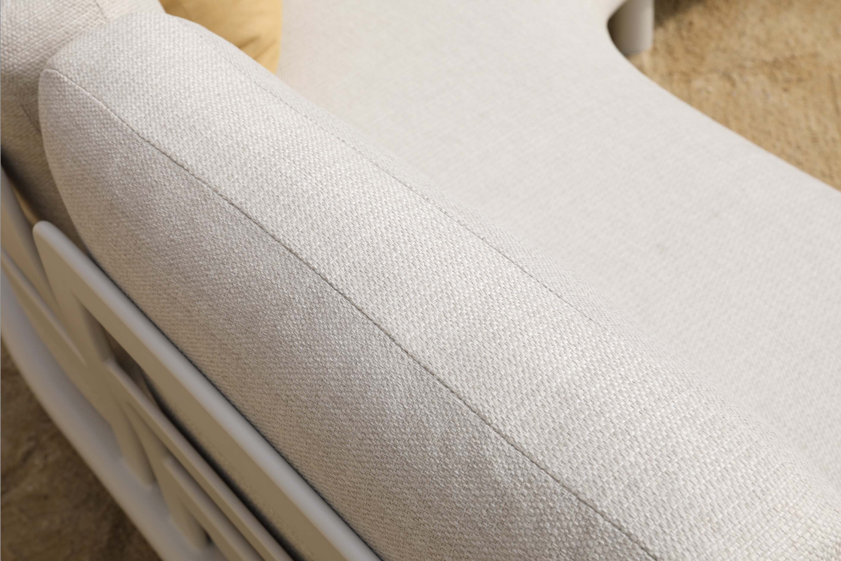 Détail du salon de jardin en aluminium haut de gamme avec courbes élégantes et peinture époxy, coussin en tissu beige.