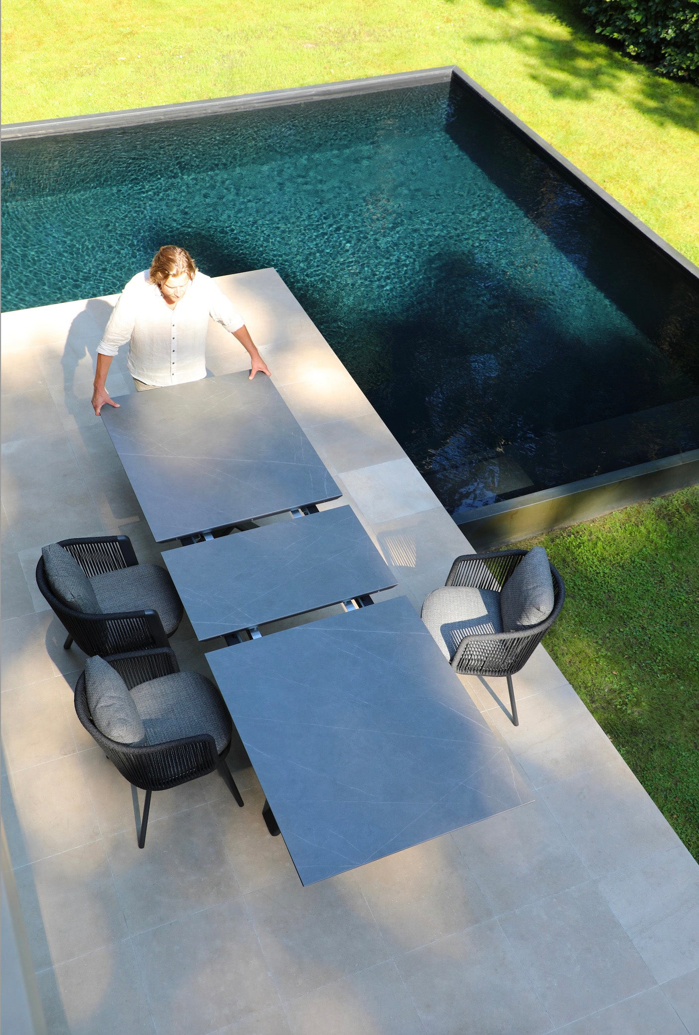 Table extensible en aluminium haut de gamme inoxydable avec grand plateau en céramique gris, design moderne élégant.