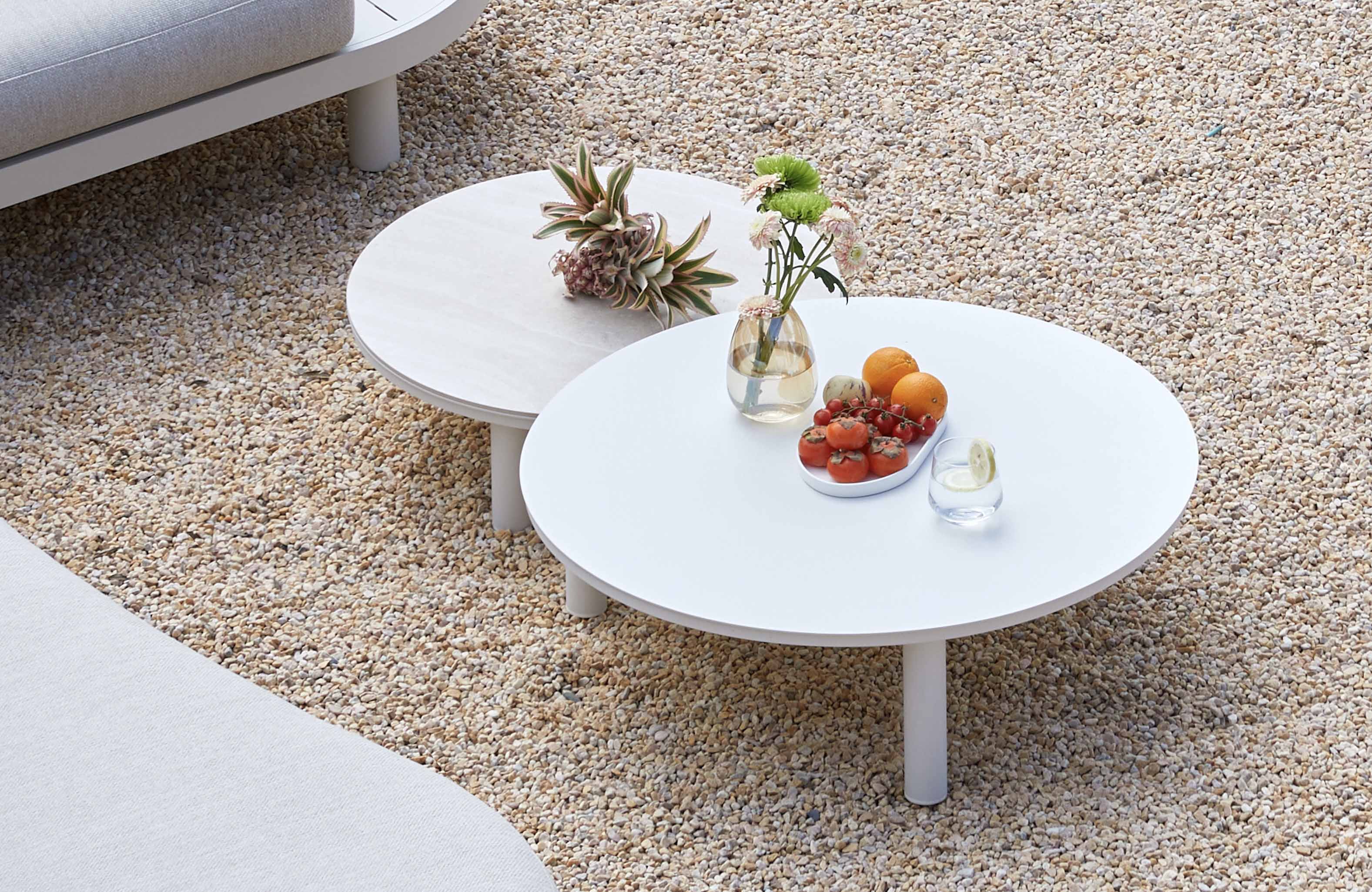 Tables basses rondes d'angle en aluminium haut de gamme à peinture epoxy blanche, design courbe élégant, posées sur galets. 