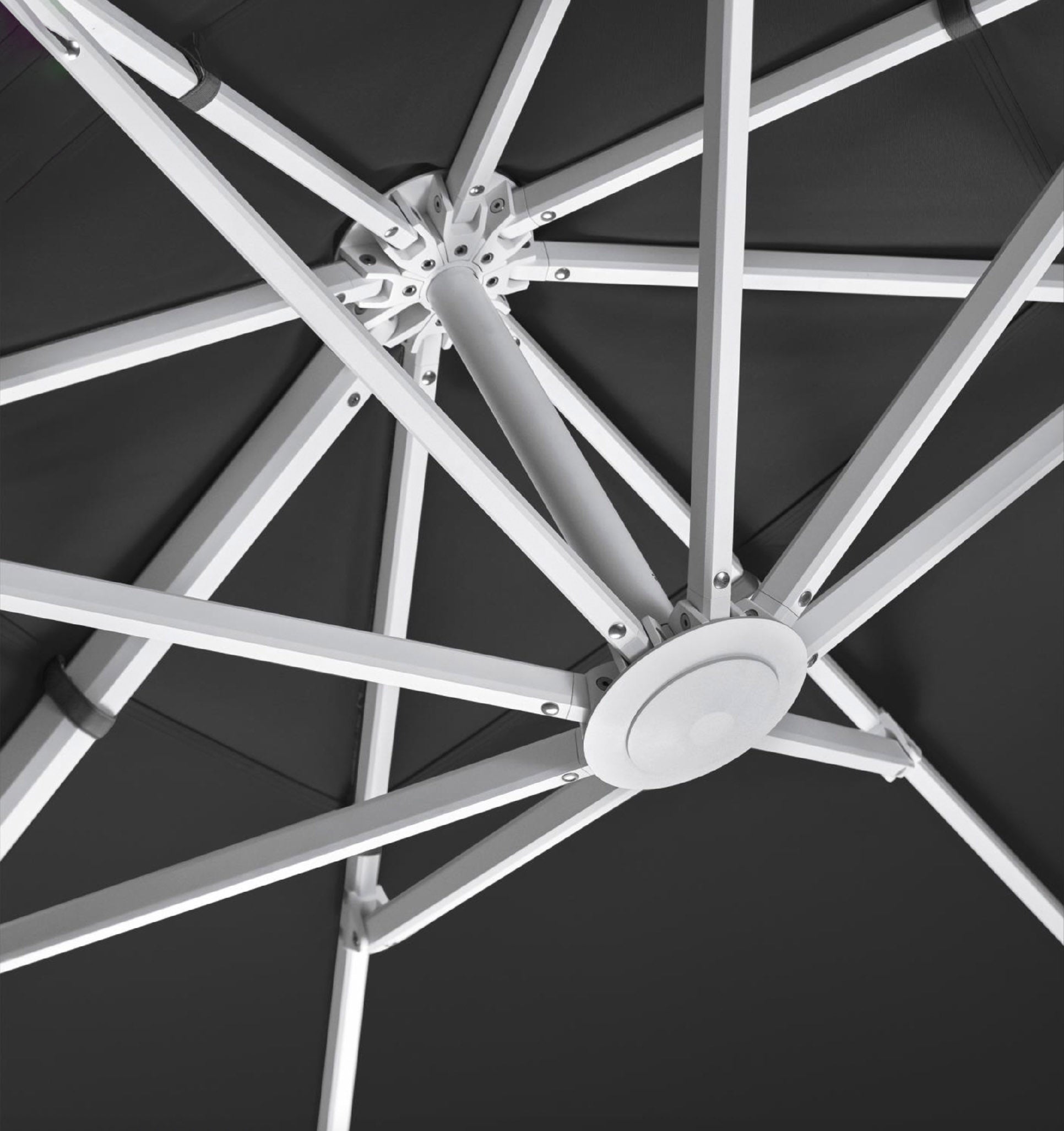 Détail structure parasol AILY Pininfarina en aluminium aviation blanc avec armature centrale inspirée des ailes et toile Sunbrella gris. 