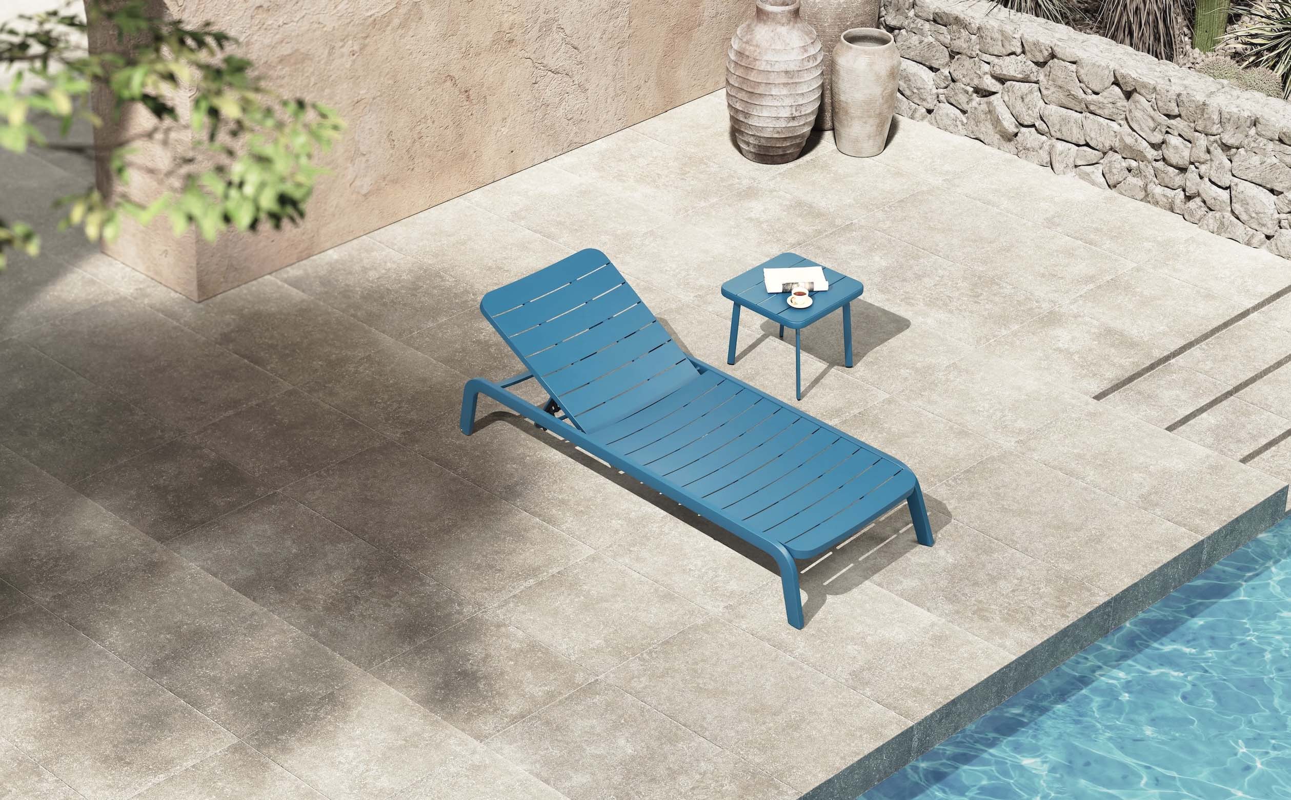 Bain de soleil empilable en aluminium haut de gamme bleu avec peinture époxy, design innovant et élégant près d'une piscine.