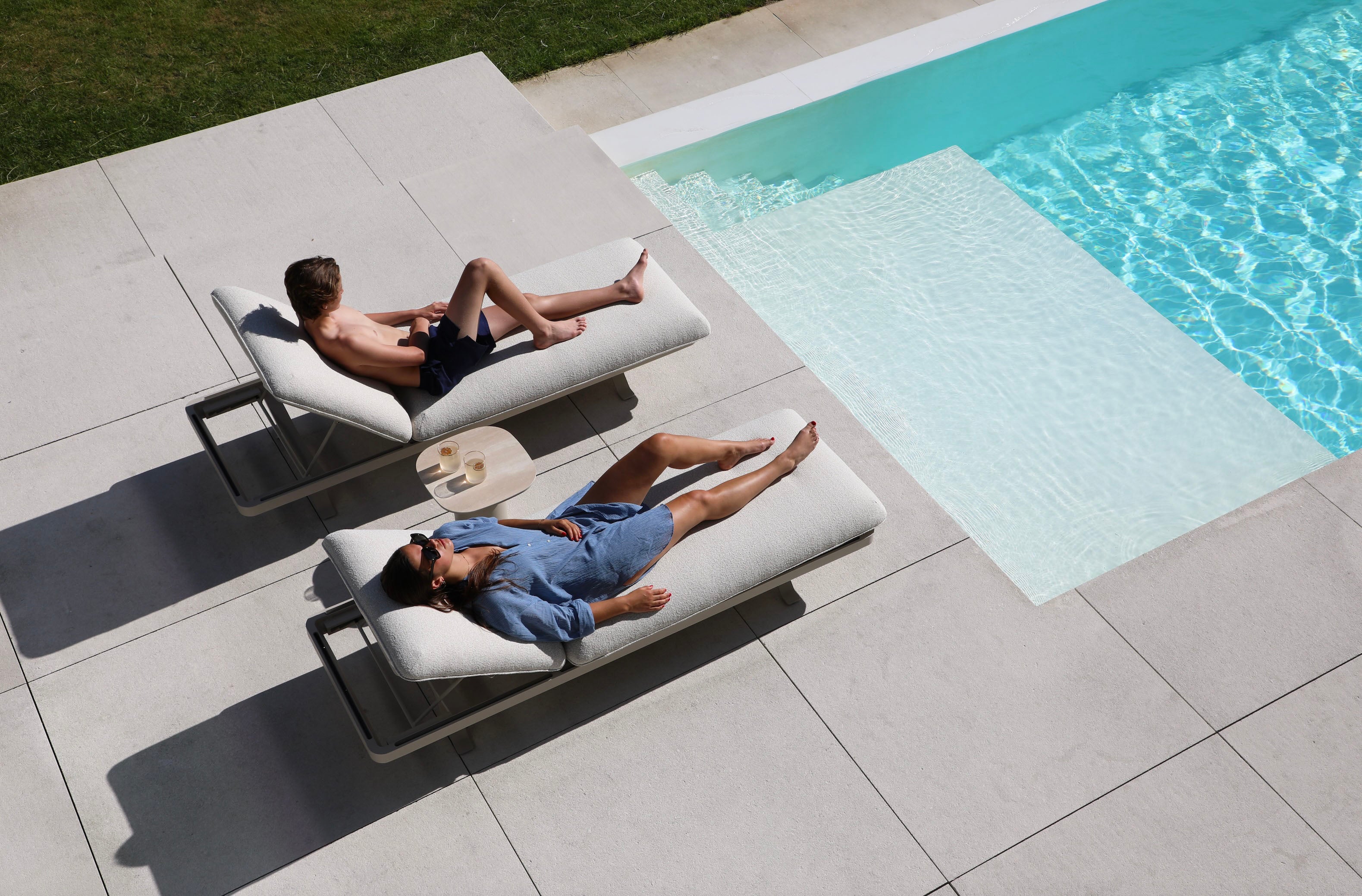 Lit de piscine design Camille en aluminium inoxydable, coussins déhoussables beige déperlants, surface céramique éclatante. 