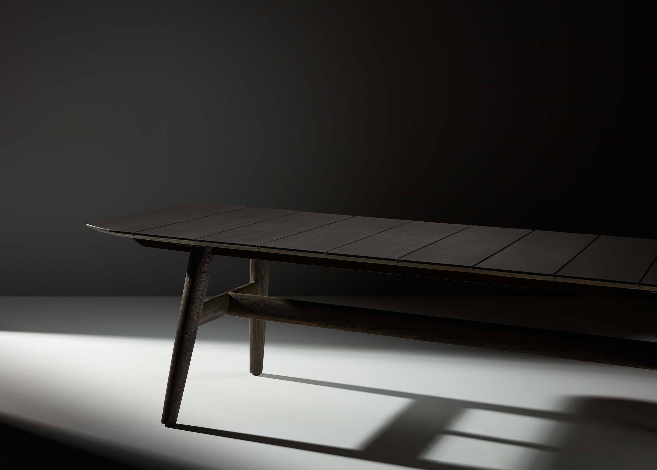Table basse luxueuse en teck FSC massif au design italien, plateau fin et pieds inclinés élégants, ambiance méditerranéenne.