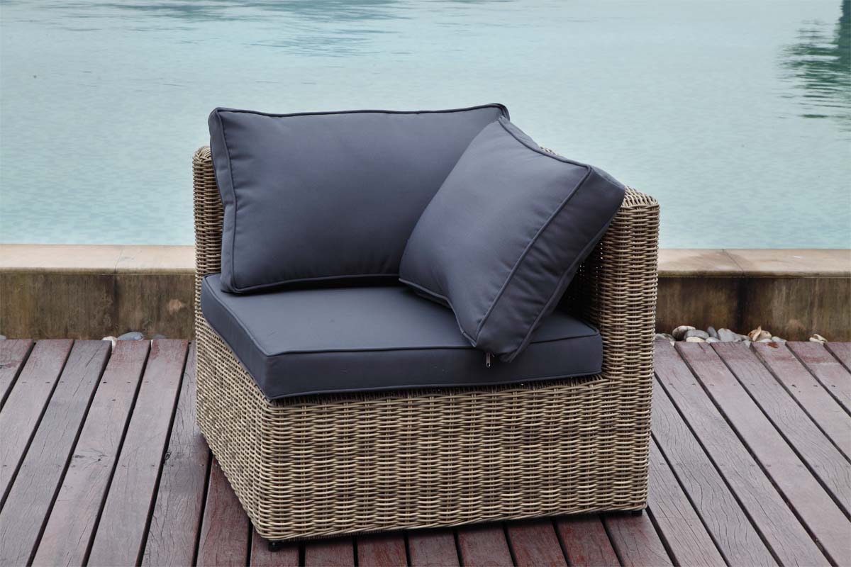 Fauteuil d’angle rustique en résine tressée ronde beige, coussins déhoussables gris déperlants, design méditerranéen élégant.