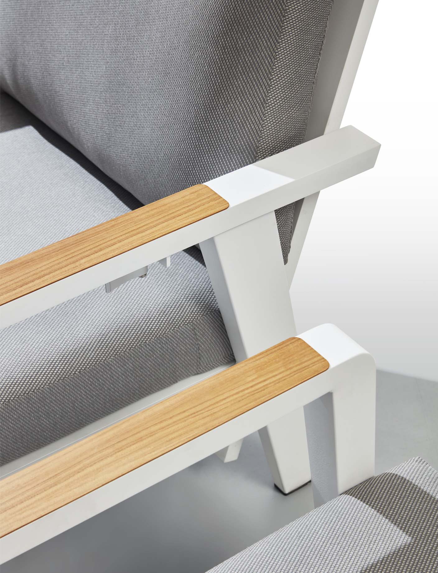 Détail d'accoudoirs en aluminium inoxydable blanc avec inserts bois clair, coussin en tissu Oléfine 100% gris clair, design.