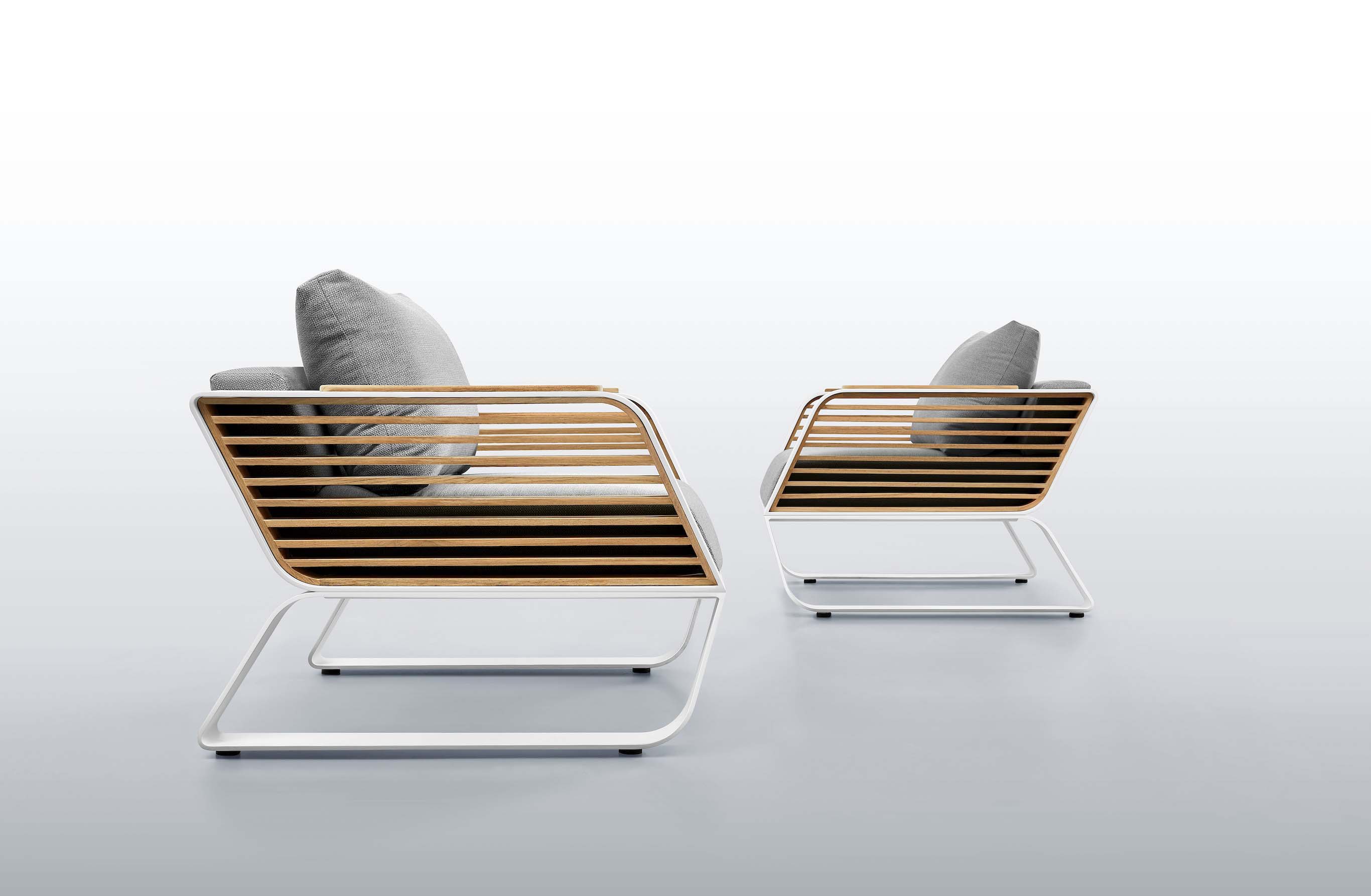 Salon de jardin haut de gamme en aluminium blanc et lattes de Teck FSC aux lignes épurées Pininfarina, coussins gris.