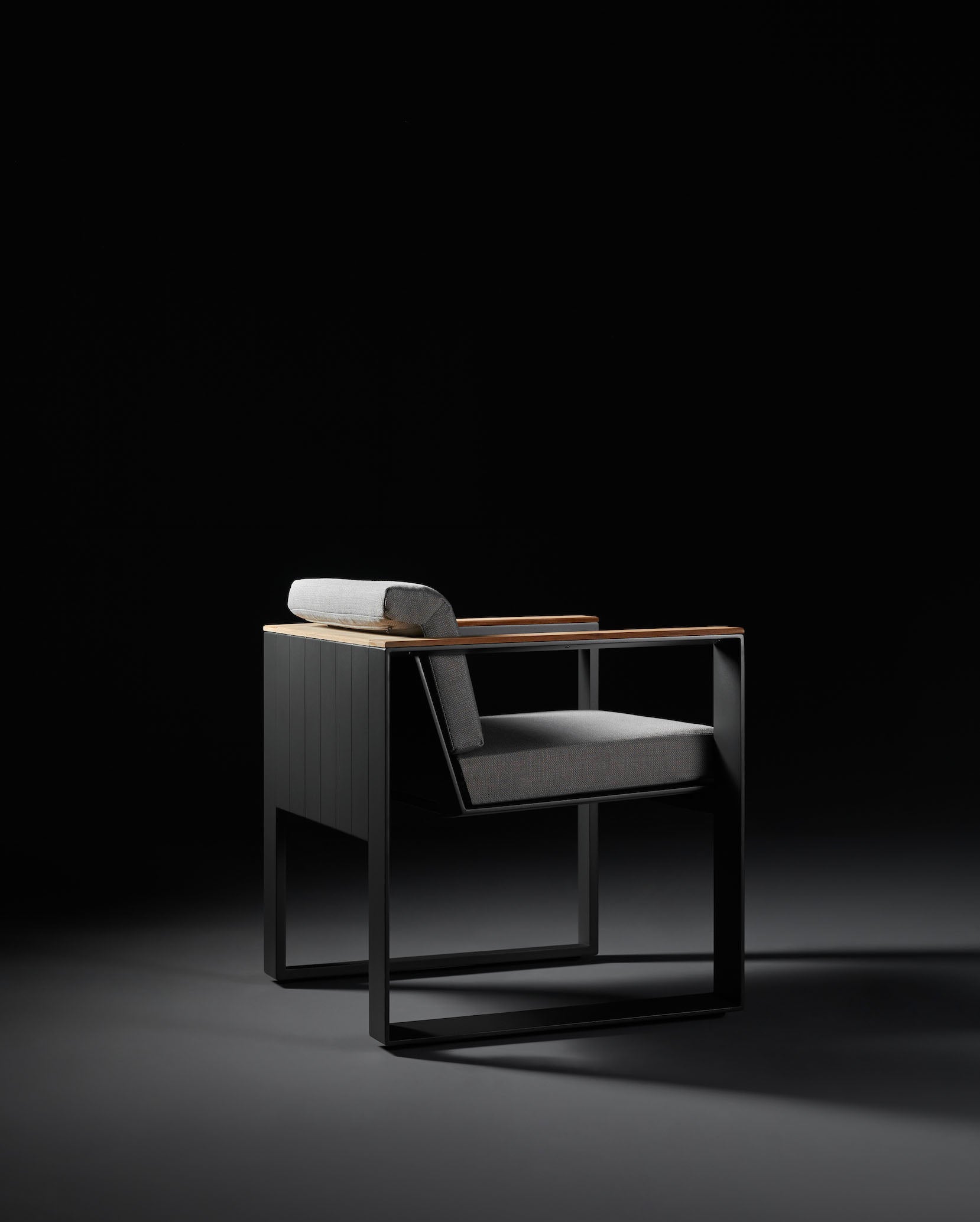 Fauteuil de jardin contemporain en aluminium noir mat avec accoudoirs en Teck SFC, coussin gris en tissu acrylique.
