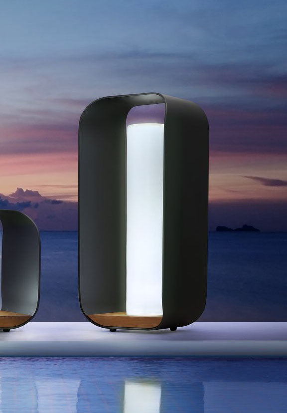 Lampe d’extérieur sans fil design Pinifarina, structure noire aux lignes courbées, base en teck FSC noble, abat-jour tissu.