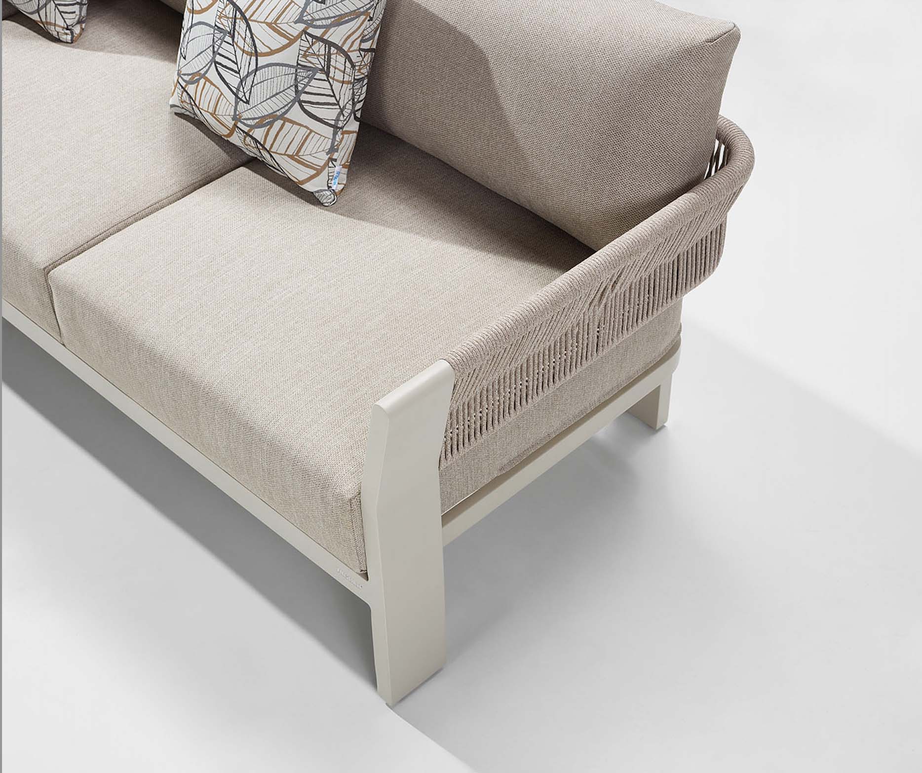 Détail canapé d'angle contemporain en aluminium blanc avec accoudoirs en corde tressée beige, coussins déhoussables déperlants.