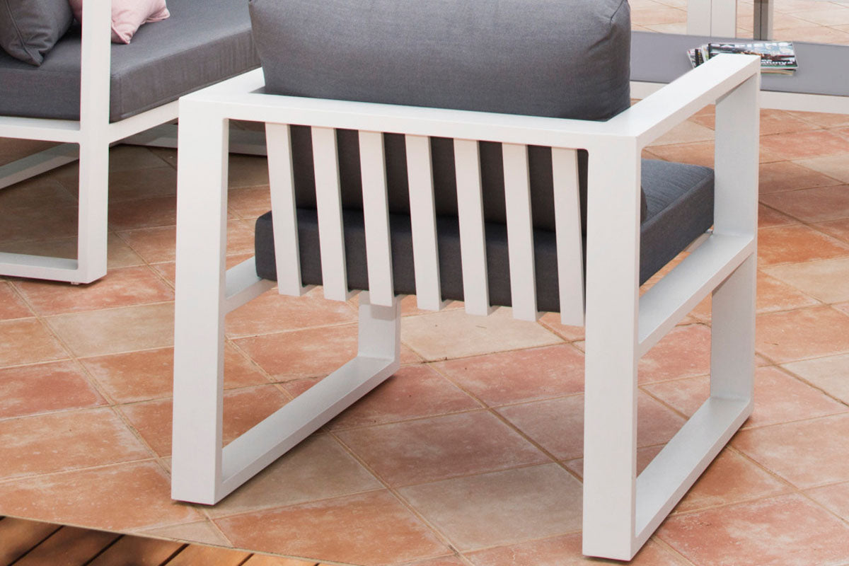 Fauteuil modulable en aluminium blanc mat avec coussins gris foncé, design élégant et durable adapté jardin extérieur luxe.