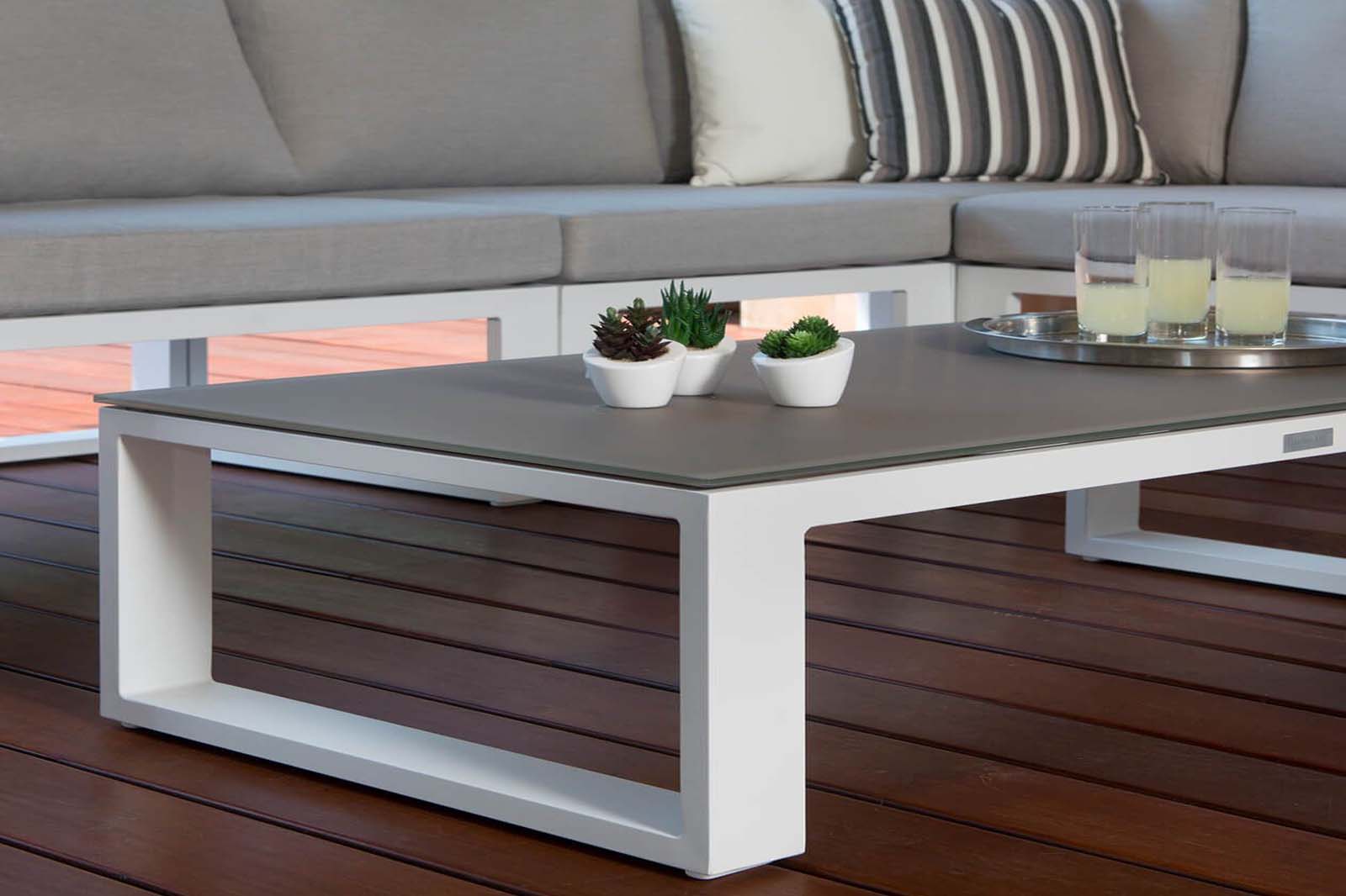Salon de jardin d'angle modulable en aluminium blanc haut de gamme, table basse élégante au design méditerranéen. 