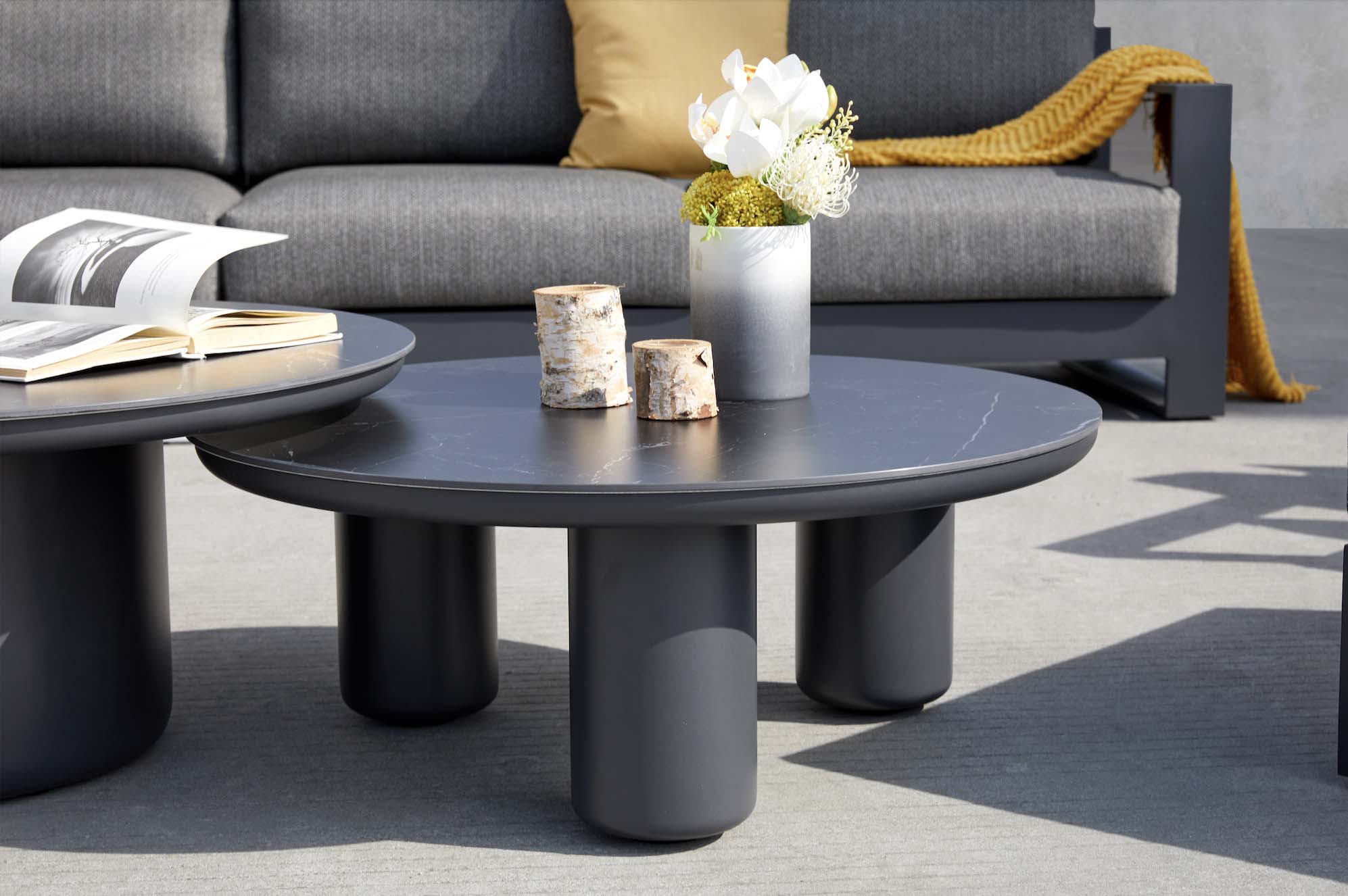 Table basse ronde en aluminium haut de gamme noir mat, design modulable, surface lisse élégante avec finition luxe, ambiance.