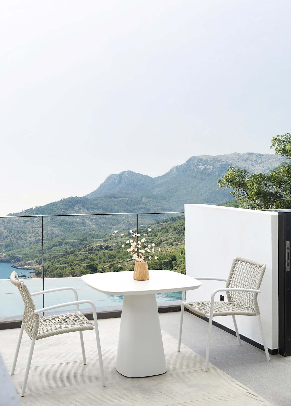 Table carré luxe en aluminium haut de gamme avec plateau en céramique blanc, base conique peinte epoxy, chaises en teck FSC.